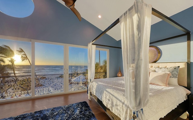 bedroom with a beach view, a water view, wood-type flooring, and lofted ceiling