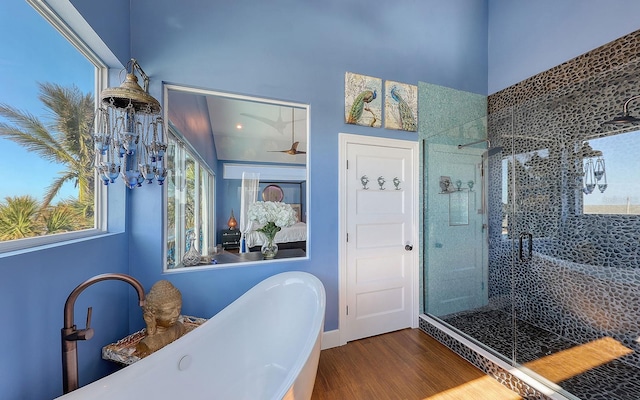 bathroom featuring wood-type flooring and shower with separate bathtub