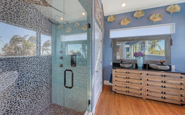 bathroom with hardwood / wood-style flooring, vanity, and an enclosed shower