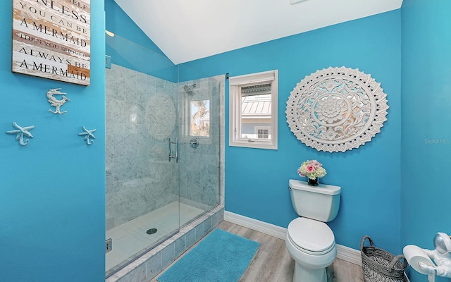 bathroom featuring toilet, a shower with shower door, vaulted ceiling, and hardwood / wood-style flooring