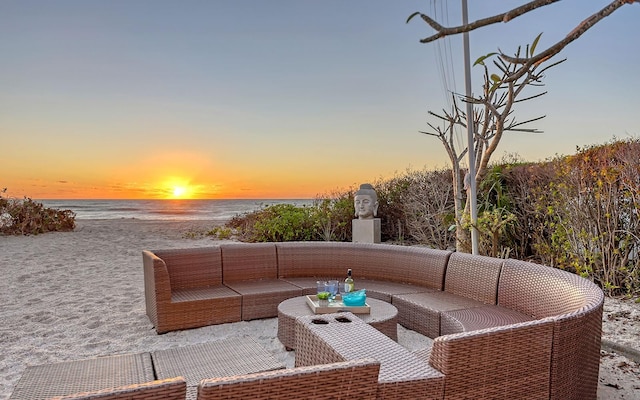 patio terrace at dusk with a water view and an outdoor hangout area