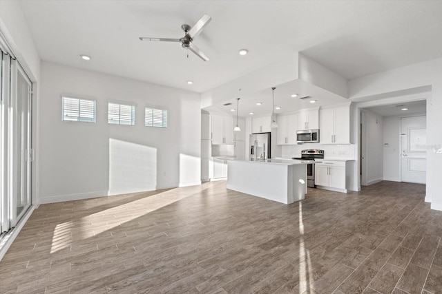 unfurnished living room featuring hardwood / wood-style floors and ceiling fan