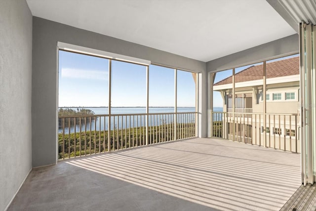 unfurnished sunroom with plenty of natural light and a water view