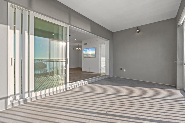 spare room featuring dark colored carpet and plenty of natural light