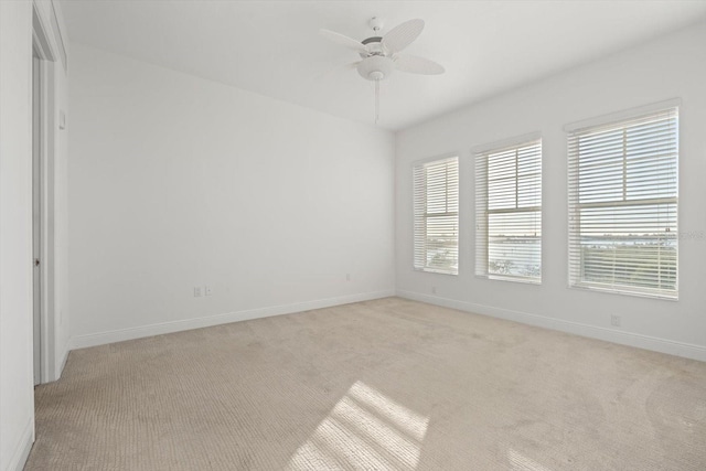 carpeted spare room featuring ceiling fan