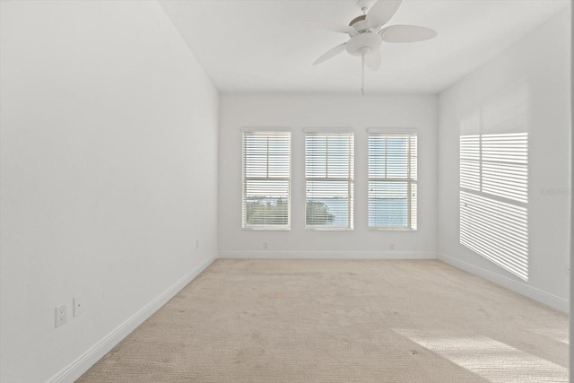 carpeted spare room with ceiling fan