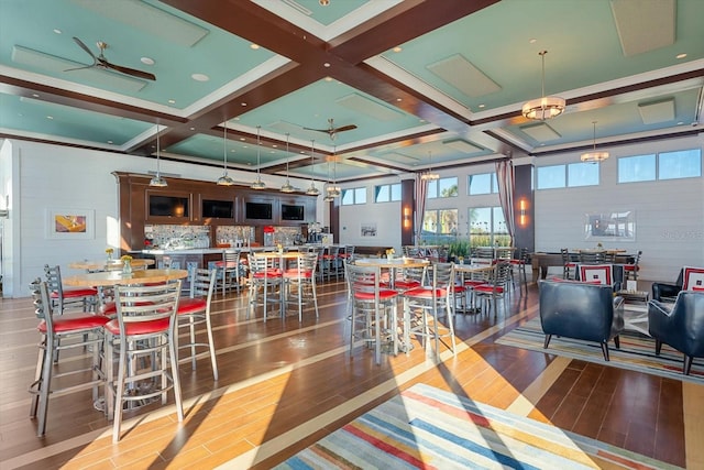 dining space featuring ceiling fan, hardwood / wood-style floors, beamed ceiling, and coffered ceiling