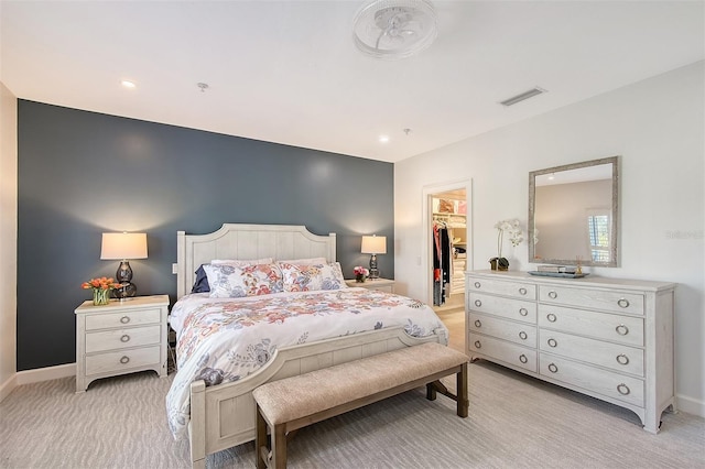 carpeted bedroom with a walk in closet and a closet