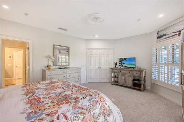 bedroom featuring light colored carpet and a closet