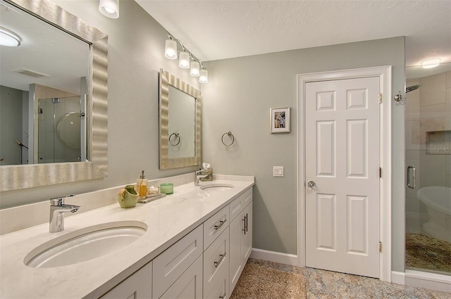 bathroom with a textured ceiling, vanity, and walk in shower