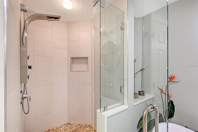 bathroom with a textured ceiling and an enclosed shower