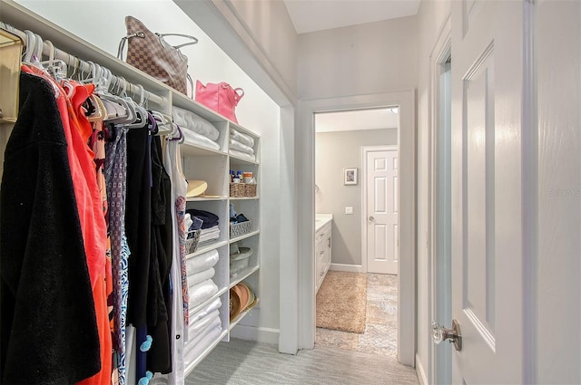 walk in closet featuring light colored carpet