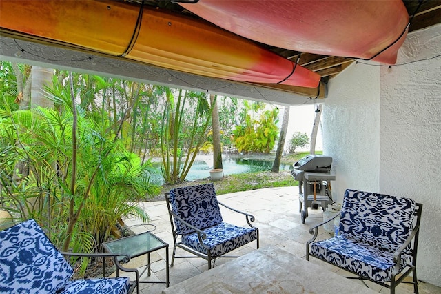 view of patio with area for grilling and a water view