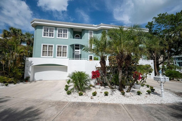 view of front facade featuring a garage, concrete driveway, and stucco siding