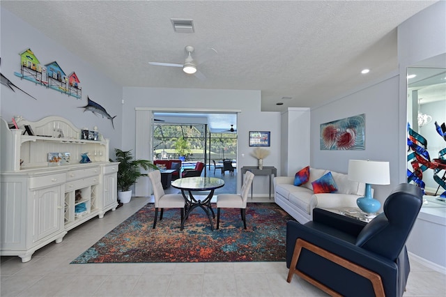 tiled living room with ceiling fan and a textured ceiling