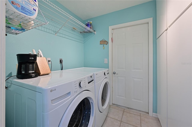 clothes washing area with separate washer and dryer and light tile patterned floors