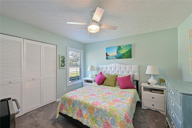 carpeted bedroom with ceiling fan, a closet, and a textured ceiling