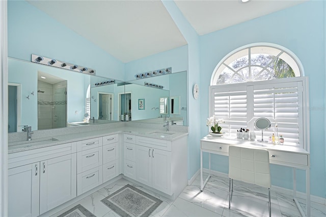 bathroom featuring vanity, a shower with shower door, and vaulted ceiling