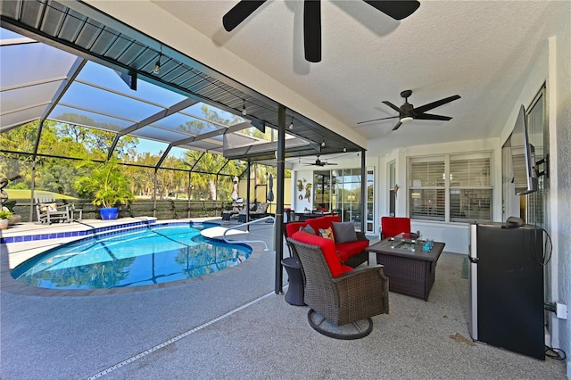 view of swimming pool featuring a patio, an outdoor hangout area, and glass enclosure