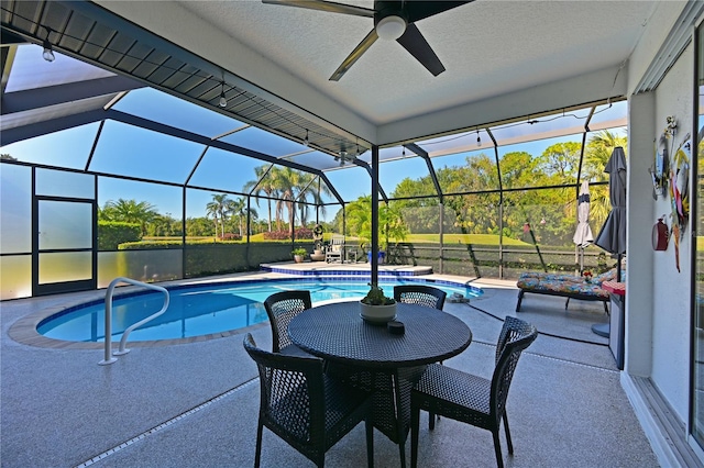 view of swimming pool with ceiling fan, a lanai, and a patio area