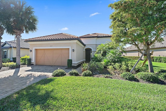 mediterranean / spanish home featuring a garage and a front yard