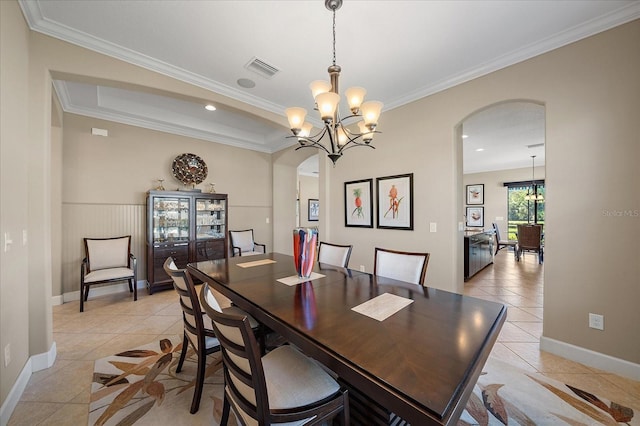 dining room featuring light tile patterned flooring, crown molding, and an inviting chandelier