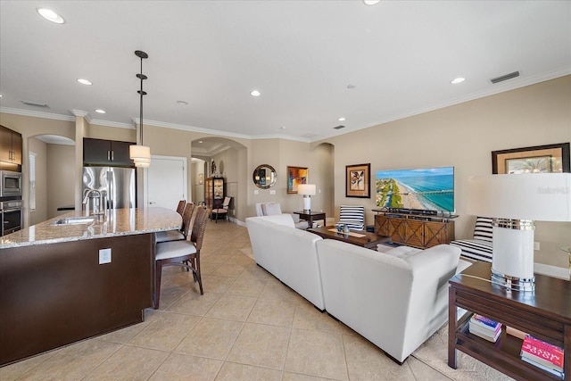 living room featuring crown molding, light tile patterned floors, and sink