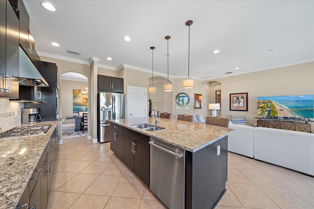 kitchen featuring stainless steel appliances, sink, pendant lighting, light tile patterned floors, and a center island with sink