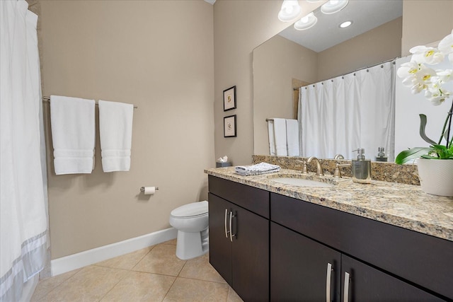 bathroom with toilet, vanity, and tile patterned floors