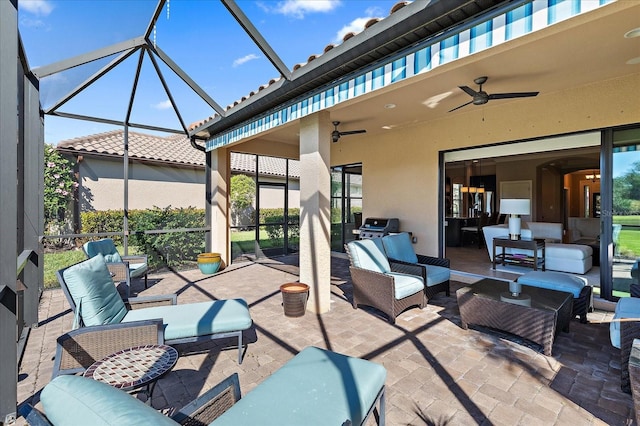 view of patio with an outdoor living space, ceiling fan, glass enclosure, and a grill