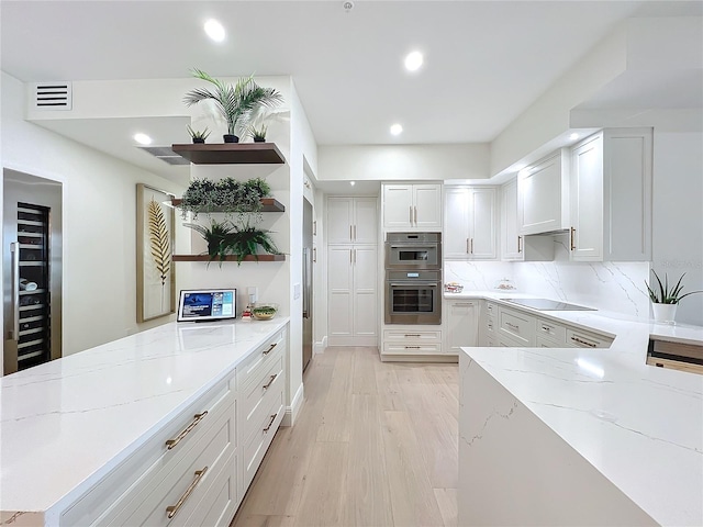 kitchen featuring white cabinets, light hardwood / wood-style floors, light stone counters, and black electric cooktop