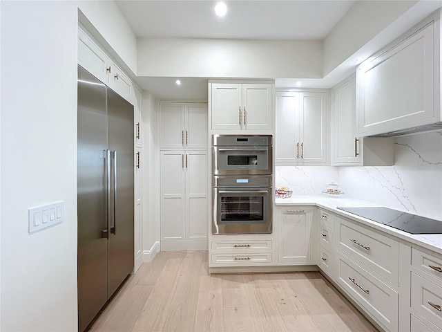 kitchen with white cabinetry, light wood-type flooring, and appliances with stainless steel finishes