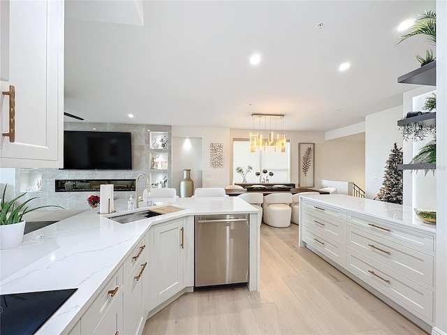 kitchen featuring dishwasher, white cabinetry, sink, and decorative light fixtures