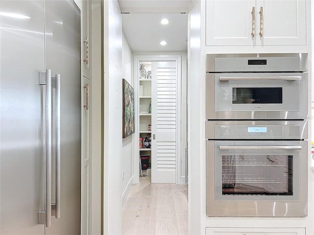 kitchen featuring white cabinetry, light wood-type flooring, and appliances with stainless steel finishes