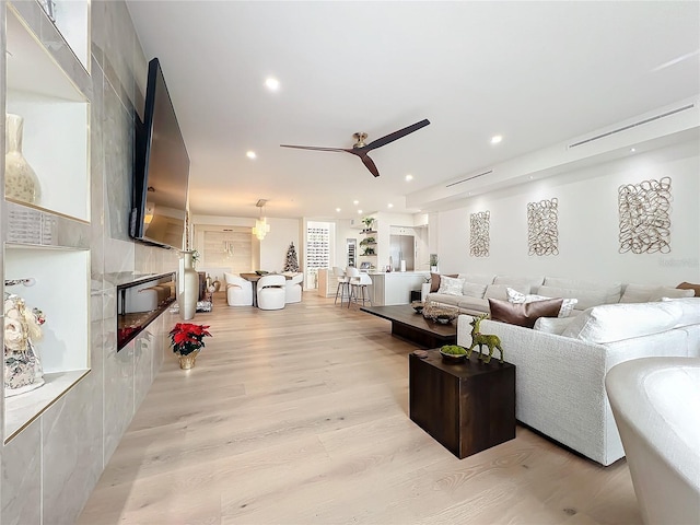 living room featuring light wood-type flooring and ceiling fan