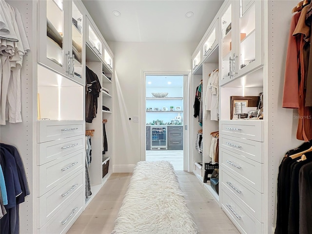 spacious closet with beverage cooler and light hardwood / wood-style flooring