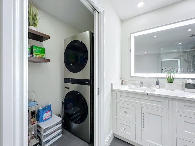 clothes washing area with stacked washing maching and dryer and sink