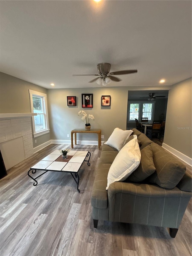 living room with light hardwood / wood-style floors and ceiling fan