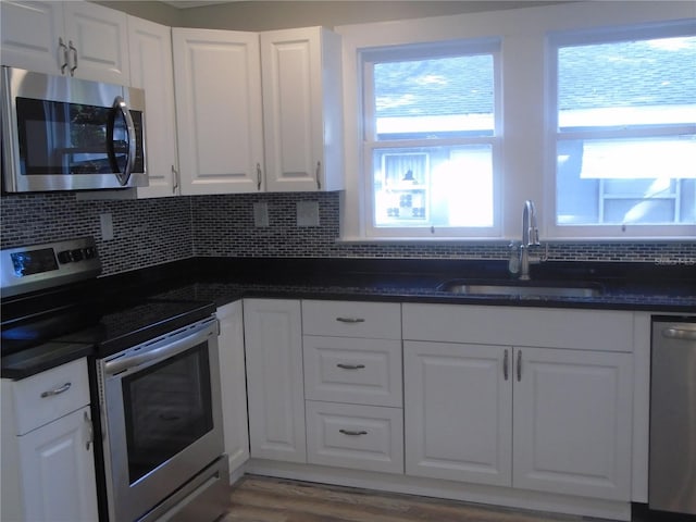 kitchen with stainless steel appliances, white cabinetry, and sink