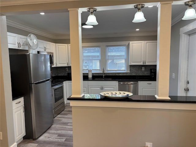 kitchen with white cabinetry, pendant lighting, and stainless steel appliances