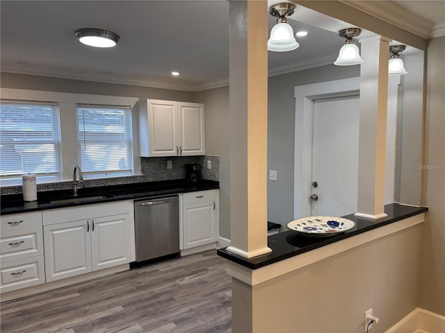 kitchen featuring dishwasher, sink, white cabinets, and hanging light fixtures