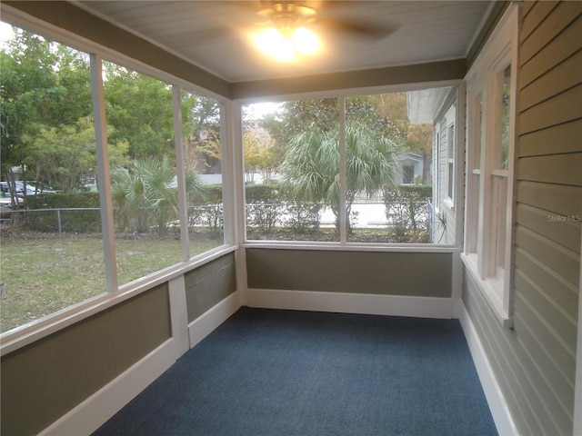 unfurnished sunroom featuring ceiling fan