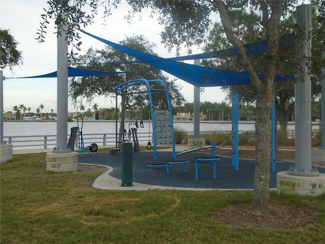 view of playground with a lawn and a water view