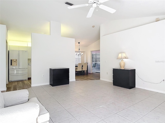 tiled living room featuring ceiling fan with notable chandelier and vaulted ceiling