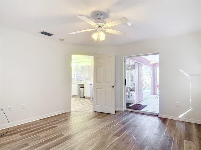 unfurnished room with hardwood / wood-style flooring and ceiling fan