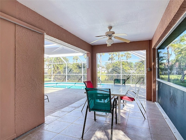 sunroom / solarium with ceiling fan and a pool