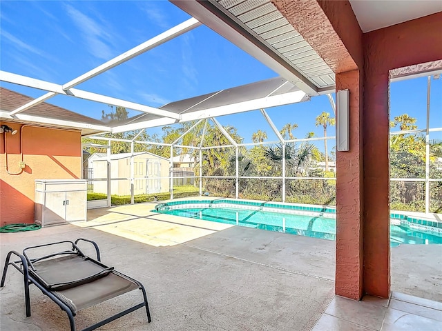 view of swimming pool featuring a storage unit, a patio, and glass enclosure