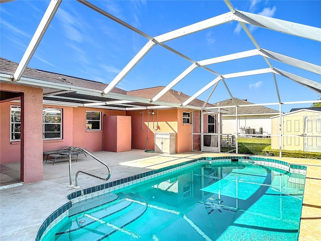 view of pool featuring glass enclosure and a patio