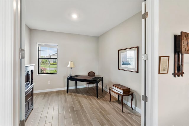 home office featuring light wood-type flooring and baseboards