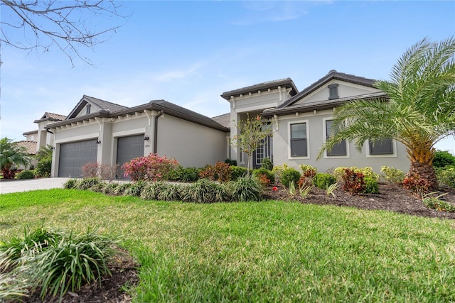 prairie-style house with a garage, driveway, a front lawn, and stucco siding